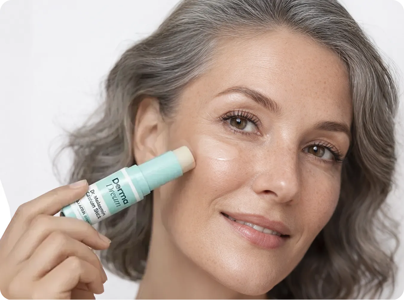 A woman applying a mint-colored skincare stick to her cheek